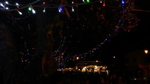 Crowd at music concert against sky at night