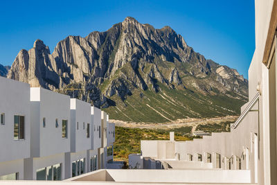 Panoramic view of rocky mountains against clear blue sky