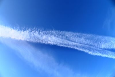 Low angle view of vapor trail against blue sky