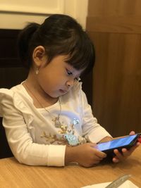 Side view of girl watching mobile phone