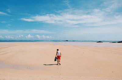 Rear view of man standing on stand at beach