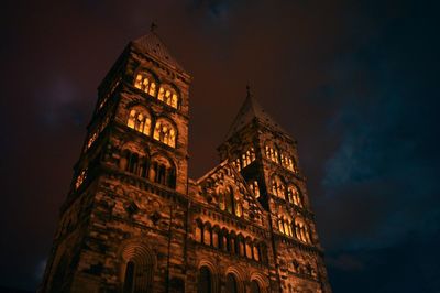 Low angle view of clock tower at night
