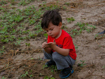 High angle view of boy holding umbrella on land