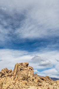 Low angle view of rock formation against sky filled with cloud formations
