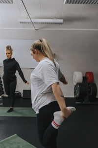 Smiling woman stretching in gym during fitness class