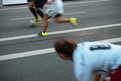 Men playing soccer on street