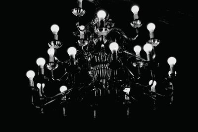 Low angle view of illuminated light bulb against sky at night