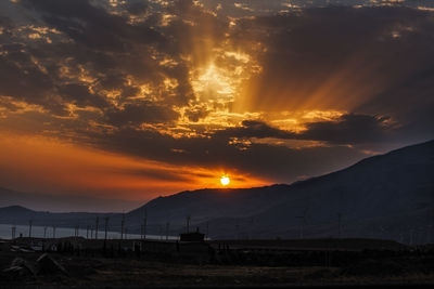 Scenic view of farm against sky during sunset