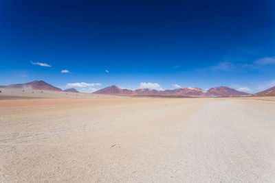 Scenic view of desert against blue sky