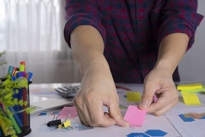 Midsection of man working on table