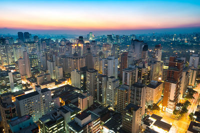 Aerial view of illuminated buildings against sky in city