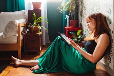 Young woman sitting on sofa at home