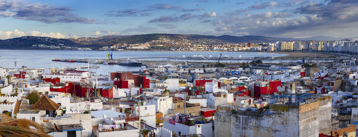 High angle view of townscape by sea against sky