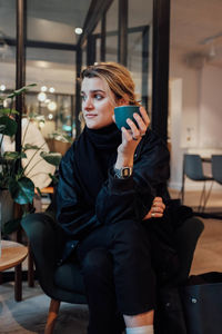 Young woman using mobile phone in restaurant