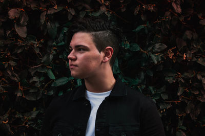 Portrait of young man looking away outdoors