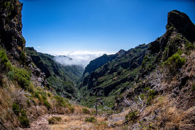 Scenic view of mountains against blue sky