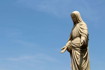 Low angle view of statue against blue sky