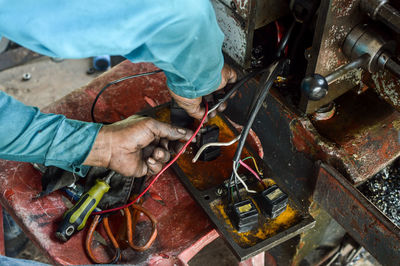 High angle view of man working on metal