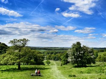 Scenic view of grassy field against cloudy sky