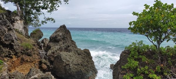 Scenic view of rocks in sea against sky