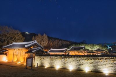 Illuminated buildings against sky at night