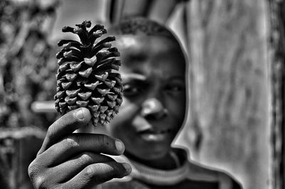 Close-up portrait of boy holding acorn