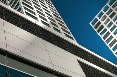 Low angle view of modern building against clear blue sky