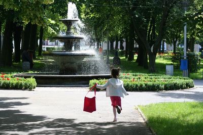 Rear view of girl walking on sidewalk