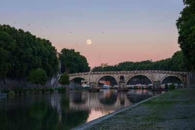 Arch bridge over river against sky