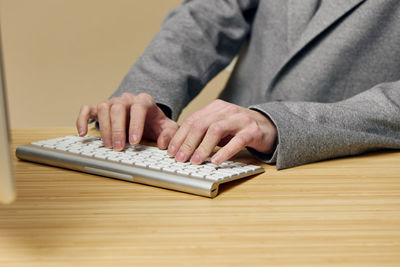 Midsection of man using laptop on table