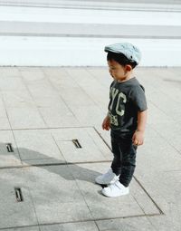 High angle view of boy standing on footpath