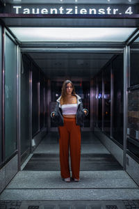 Full length of young woman standing in corridor