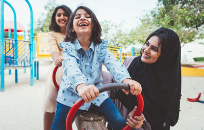 Mother with cheerful daughters enjoying at park