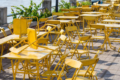 Empty chairs and tables at sidewalk cafe