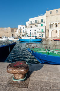 Boats moored on sea against buildings in city