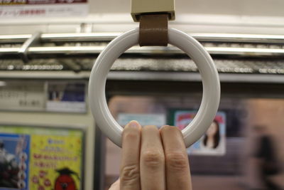 Close-up of hand holding handle in train