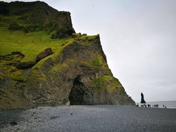 Rock formation at beach against sky