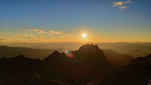 Scenic view of silhouette mountains against sky during sunset