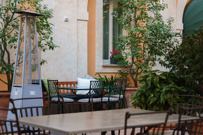 Empty chairs and table by building