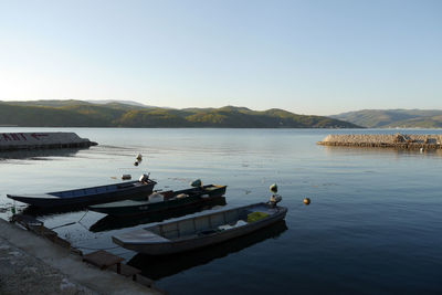 Boat moored on lake against clear sky