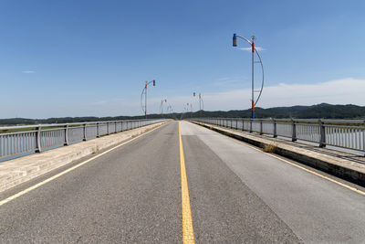 Road by bridge against sky