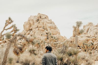 Rear view of man standing against sky