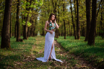 Full length of woman standing in forest