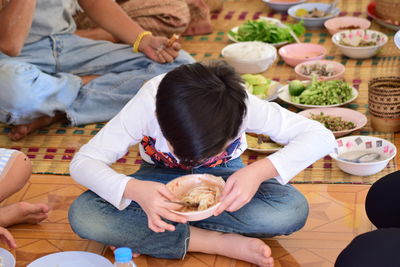 High angle view of boy eating noodles in bowl