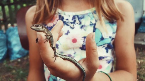 Midsection of girl holding lizard