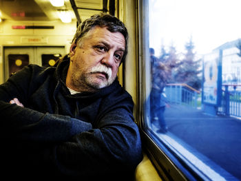 Senior man looking through train window