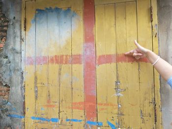 Person hand on multi colored wall