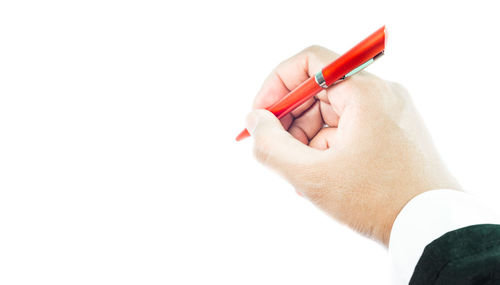 Close-up of hand holding cigarette over white background