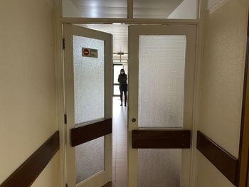 Rear view of man standing at entrance of building