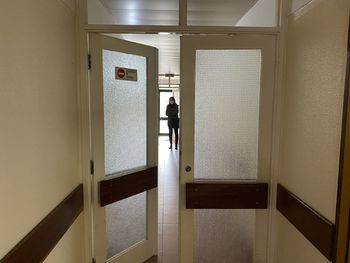 Rear view of man standing at entrance of building